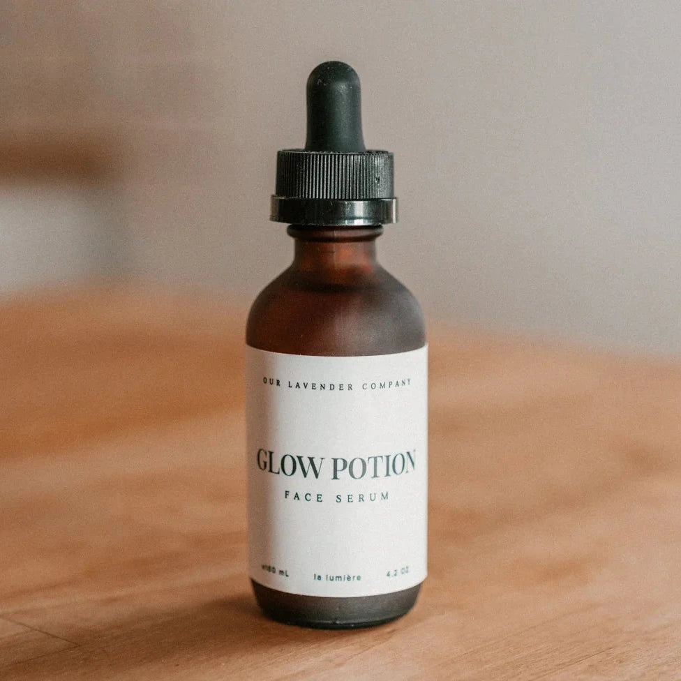 Bottle of 'Glow Potion' face serum on a wooden surface with a neutral background