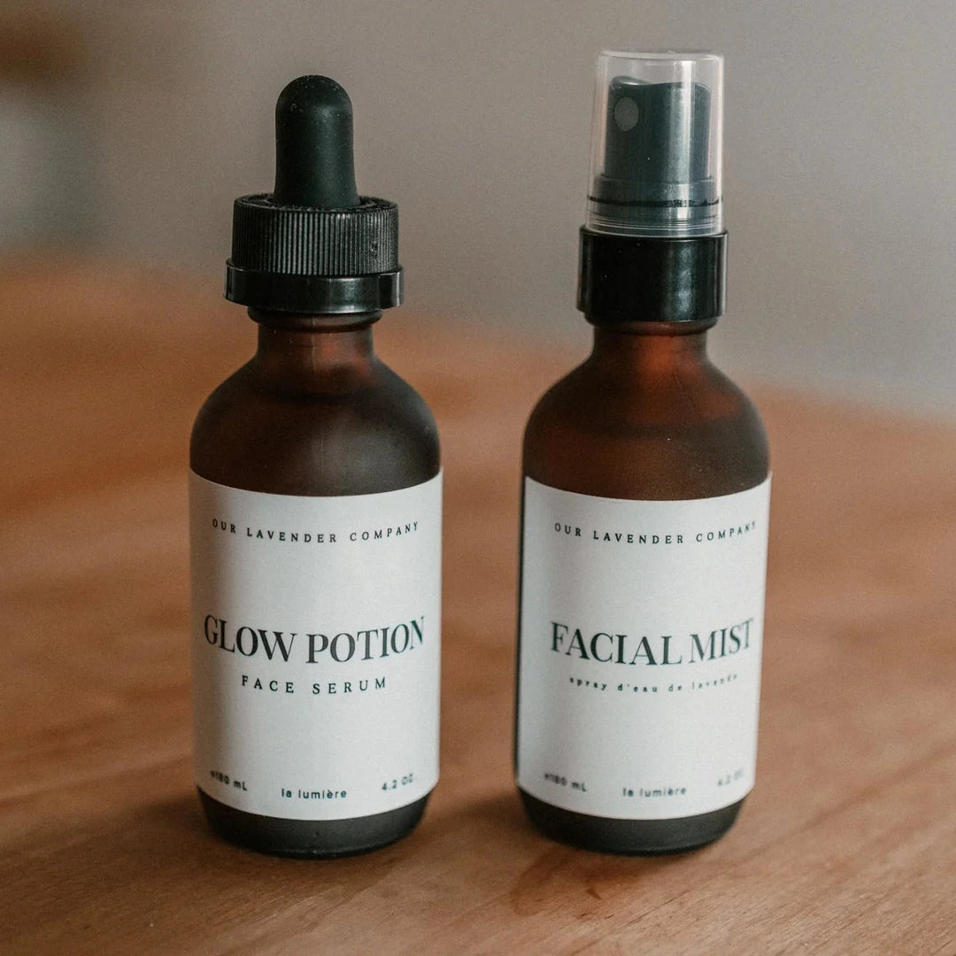 Two skincare bottles labeled 'Glow Potion' and 'Facial Mist' on a wooden surface.