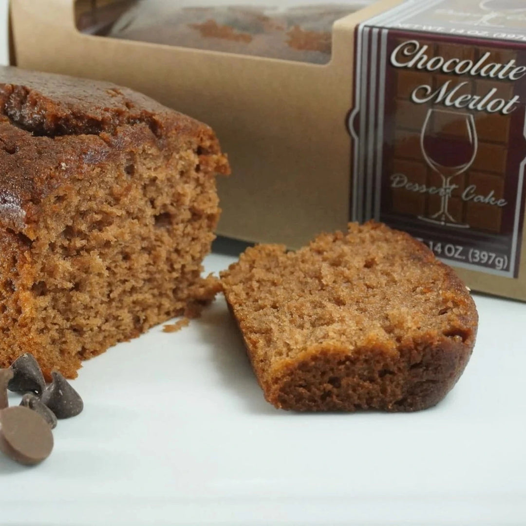 Chocolate Merlot dessert cake with a slice cut, displayed in front of its packaging.