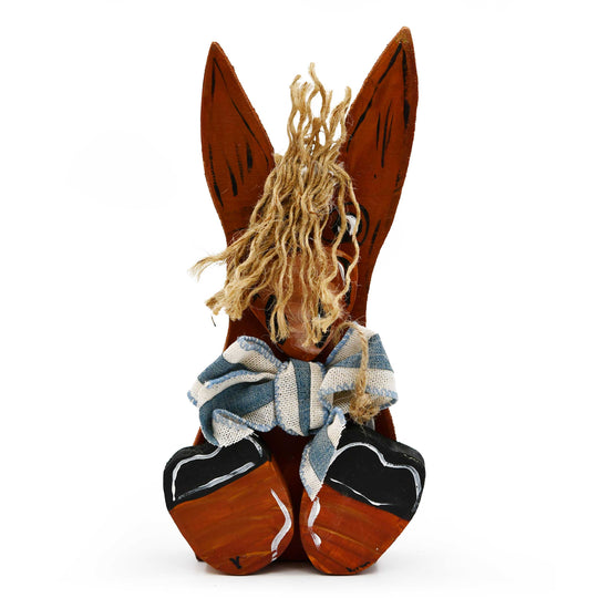 Wooden horse head with braided hair and a striped scarf on a white background