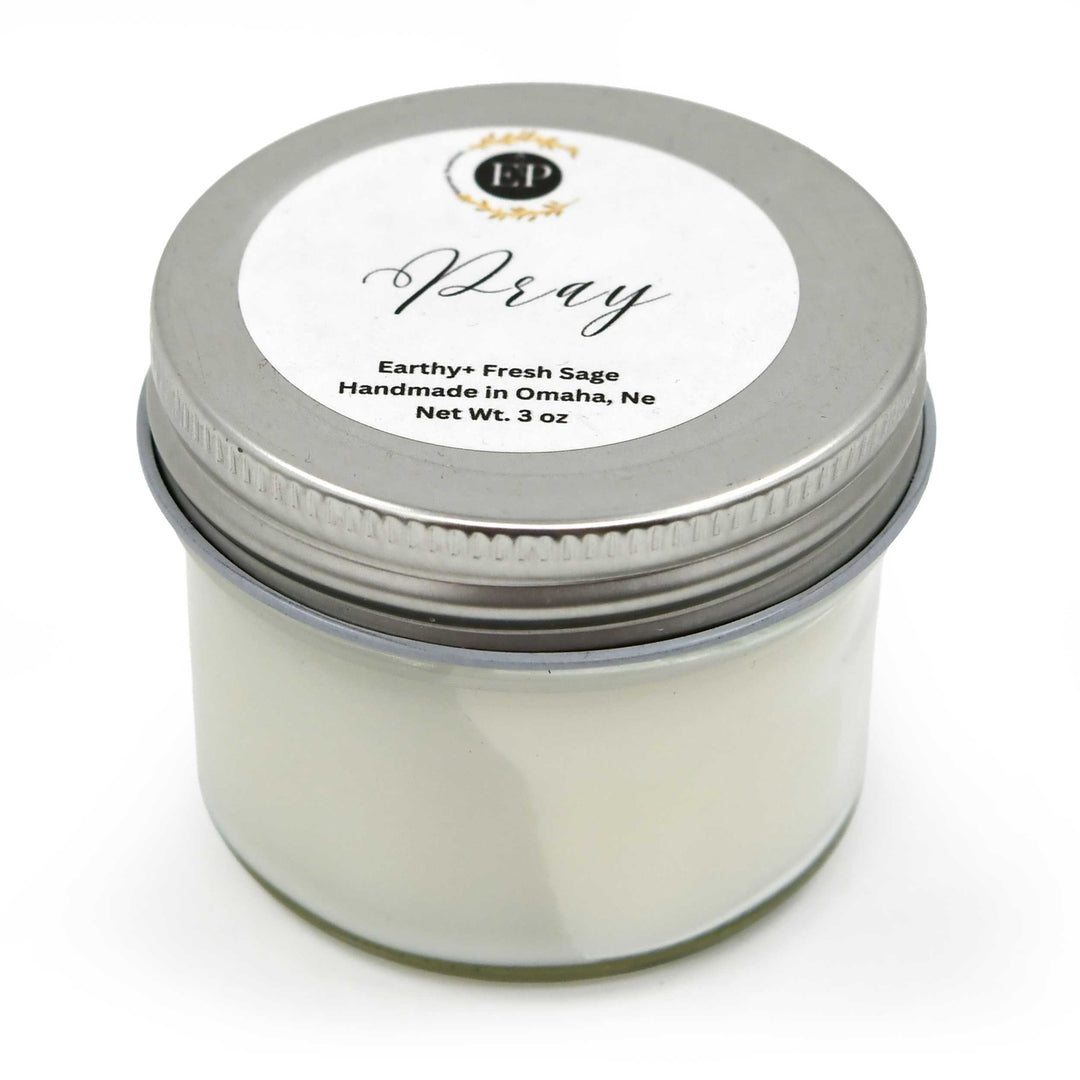 Candle jar with a silver lid and white label on a white background