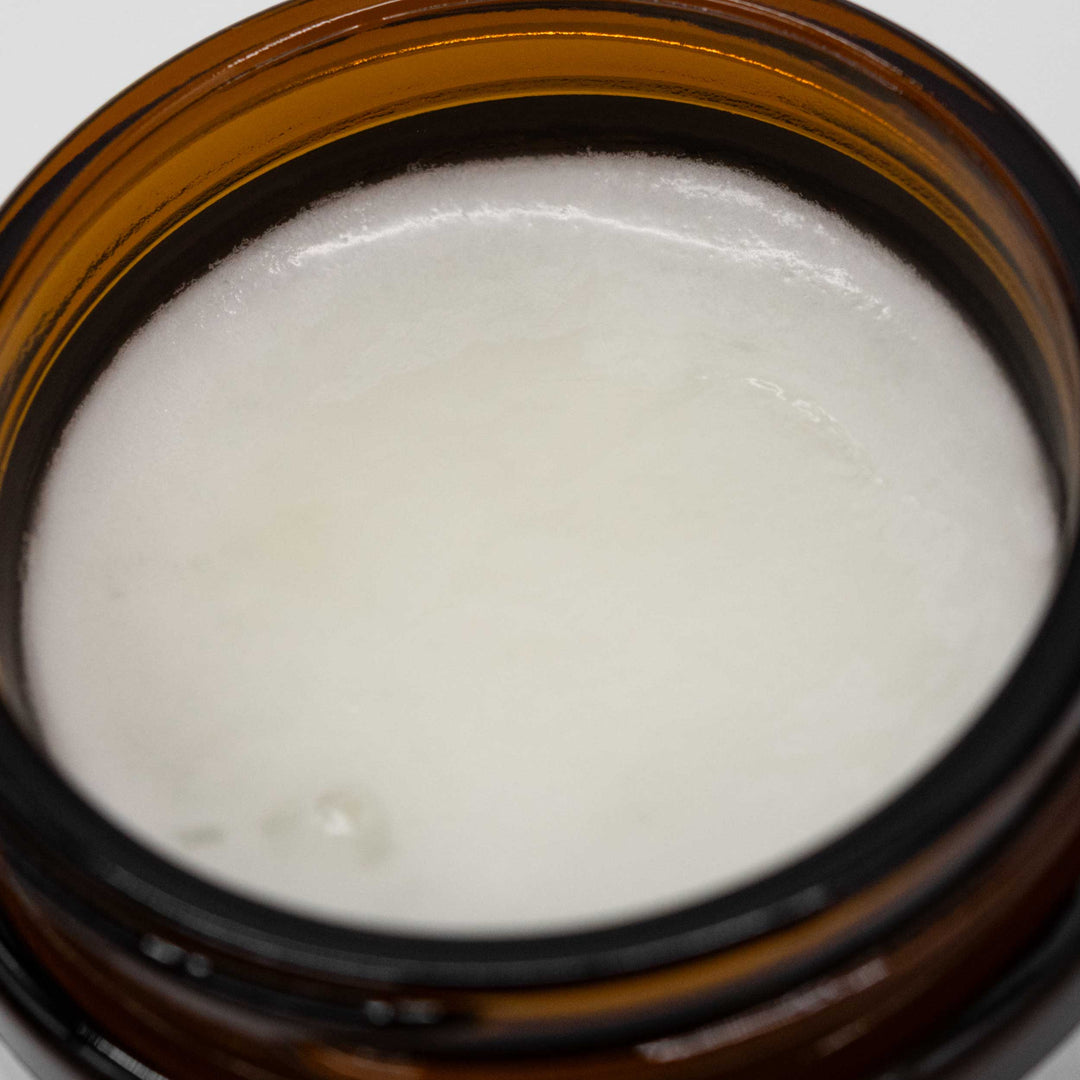 Close-up of a brown jar with white cream inside
