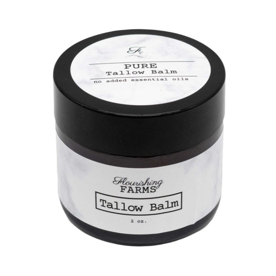 Tallow balm jar with black lid and white label on a white background