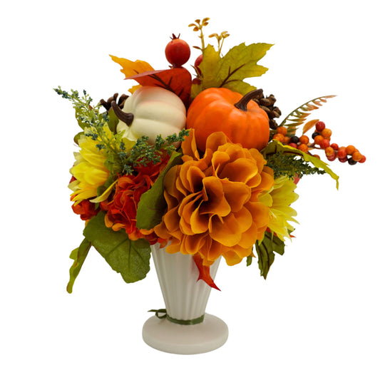 Autumn-themed floral arrangement with pumpkins and berries in a white vase on a white background