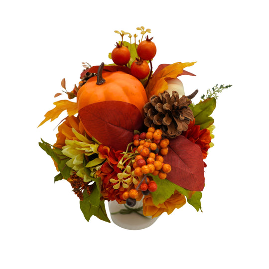 Autumn-themed floral arrangement with pumpkins, leaves, and berries on a white background