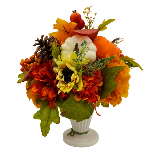 Autumn-themed floral arrangement with pumpkins and leaves in a white vase on a white background