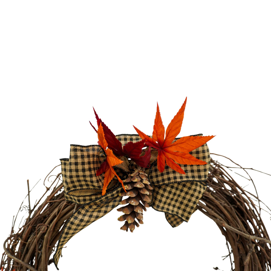 Decorative wreath with autumn leaves and pinecones on a white background
