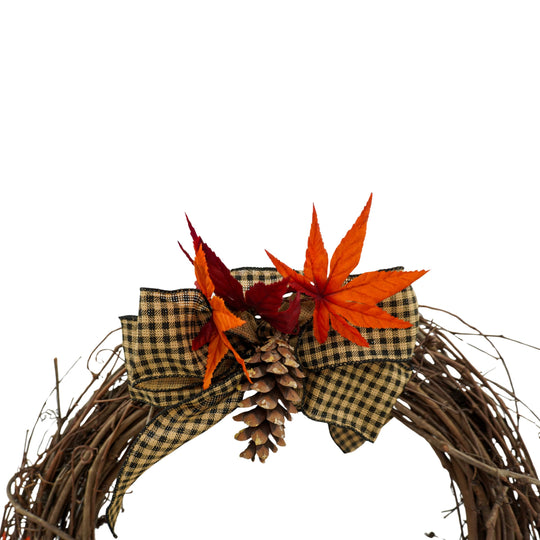 Decorative wreath with autumn leaves and pinecones on a white background