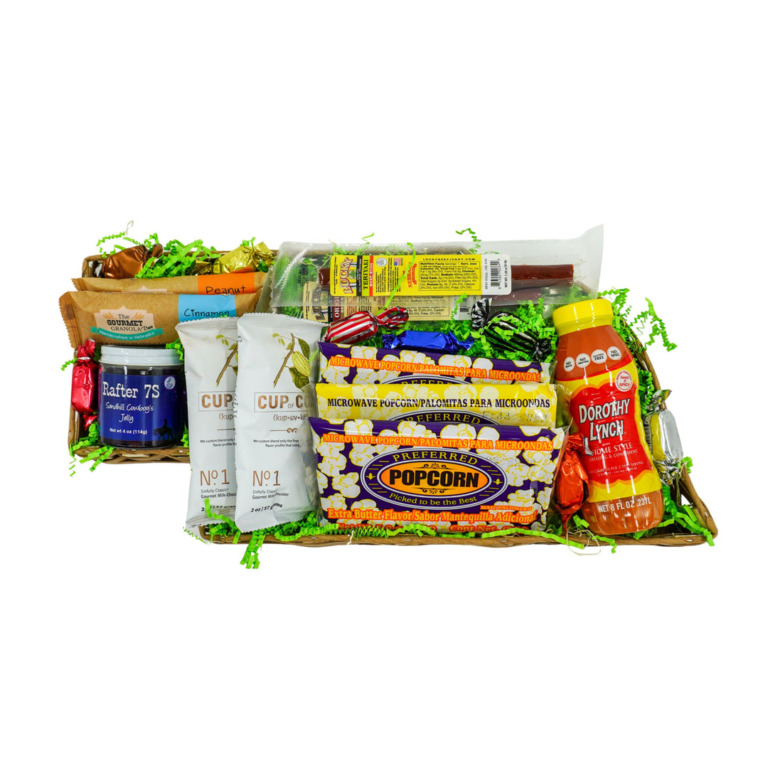 Gourmet gift basket with popcorn, chips, and other snacks on a white background