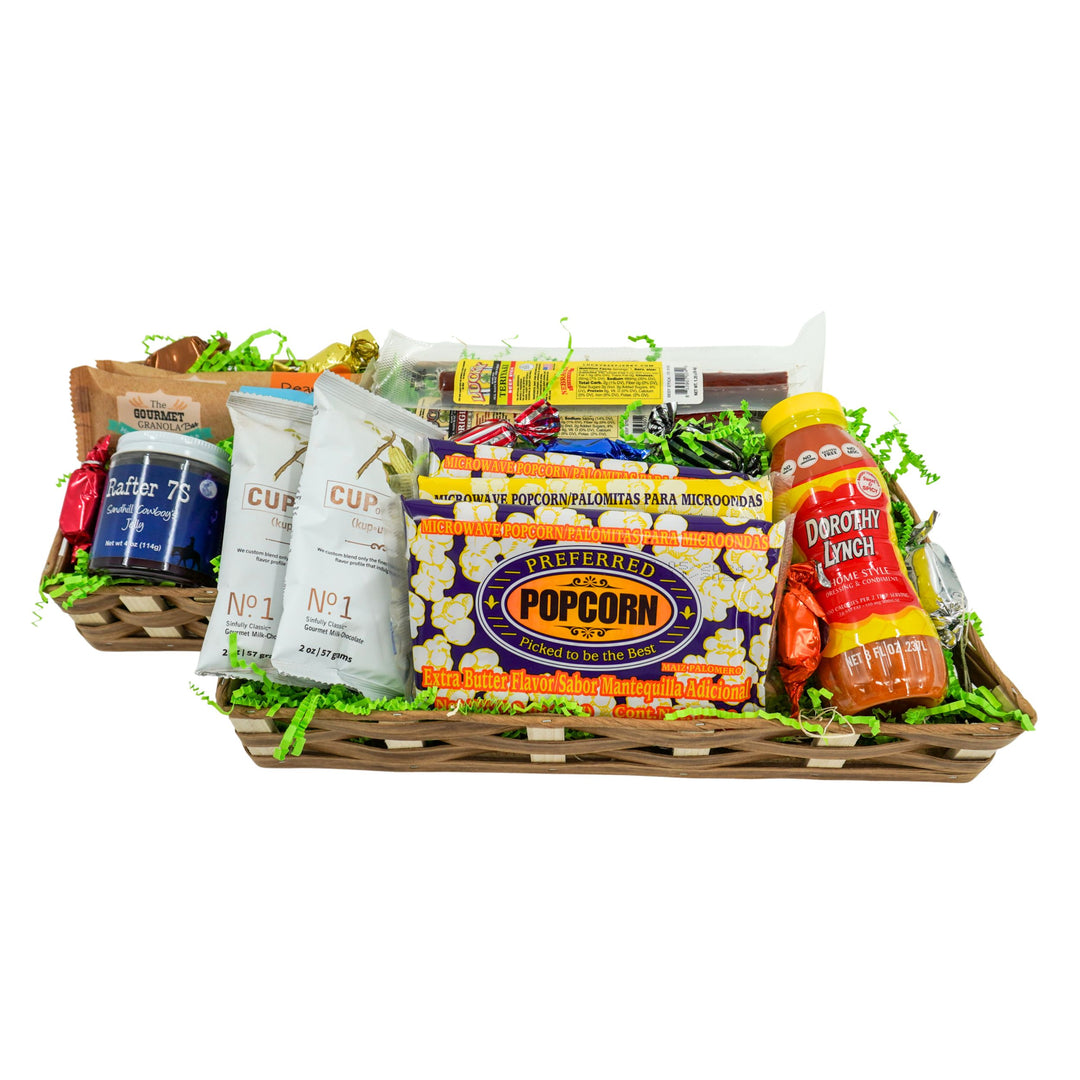 Gourmet gift basket with popcorn, chips, and other snacks on a white background