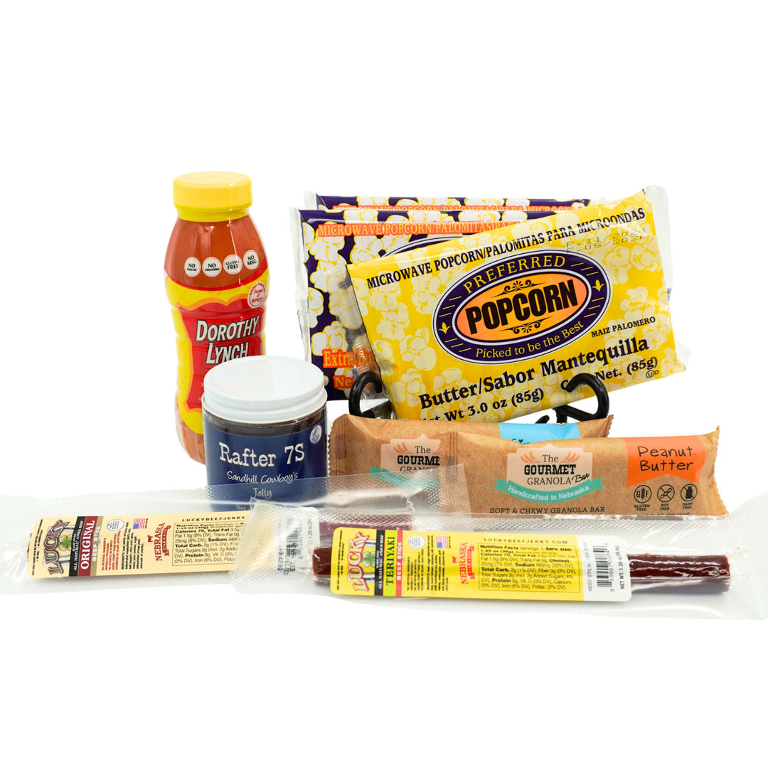 Assorted snacks including a bottle, popcorn, granola bars, and a jar on a white background