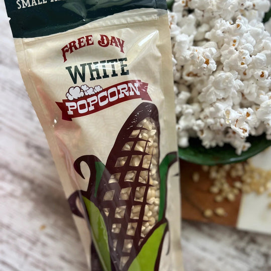 Free Day White Popcorn bag with popcorn in the background