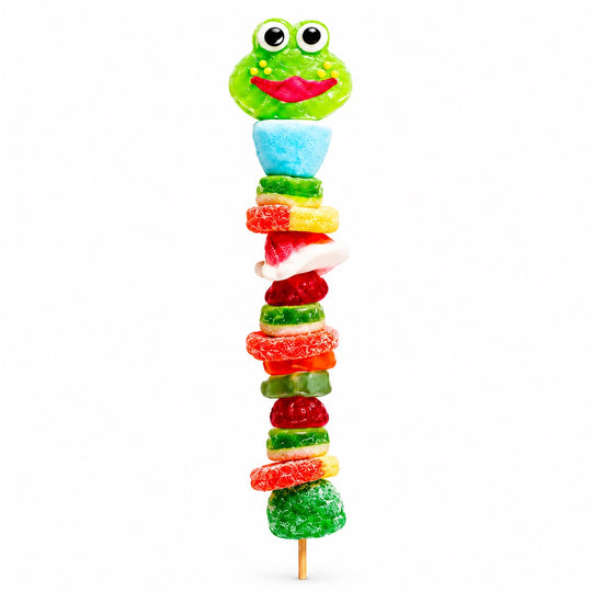 Green frog candy kabob featuring a frog-shaped gummy topper and assorted colorful gummies on a wooden skewer against a white background.