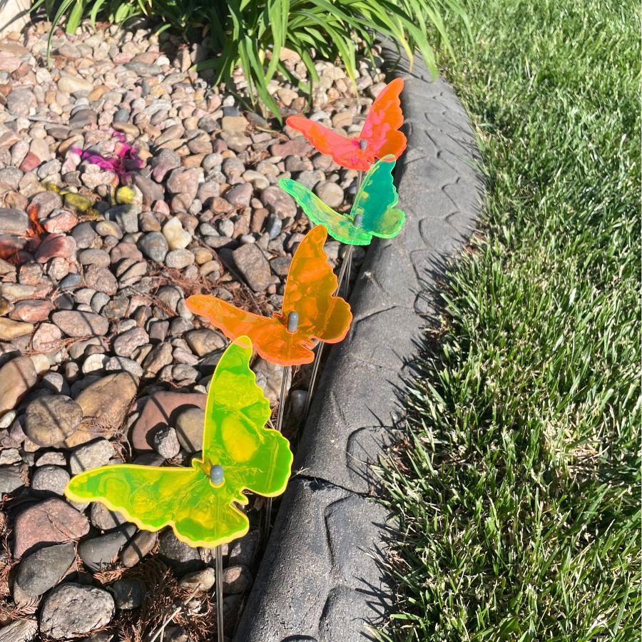 A four pack of glowing butterflies in rocks. Colors: Pink, Green, Orange, Yellow