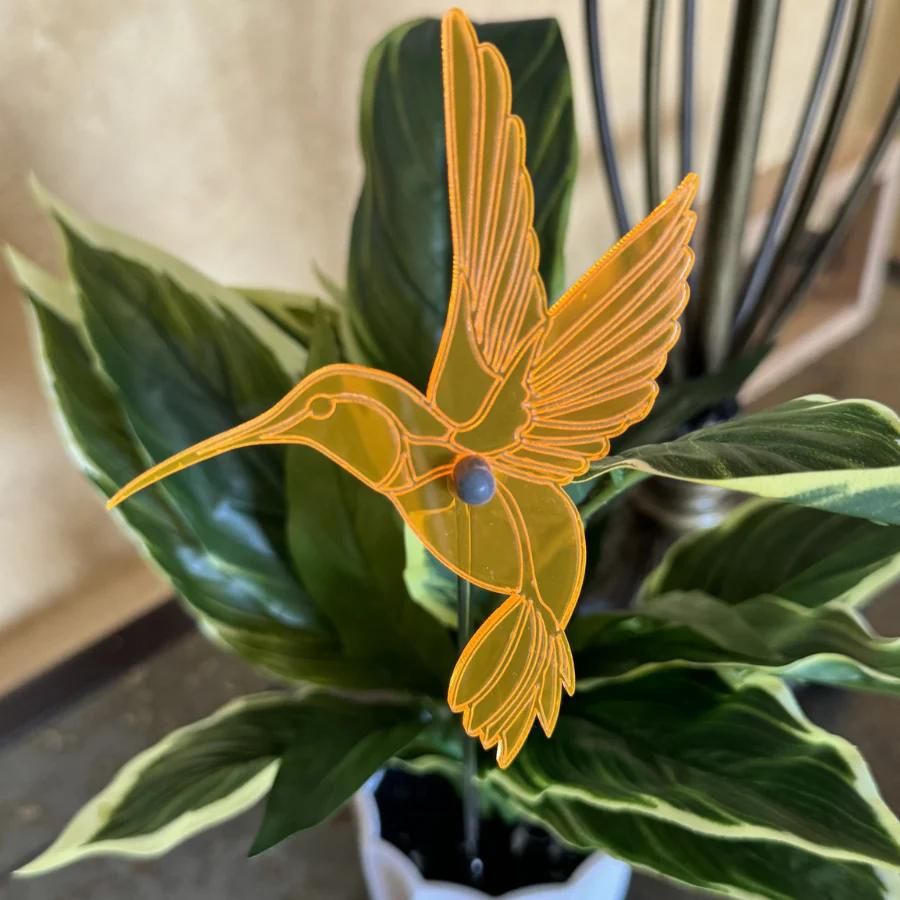 An orange glowing hummingbird in leaves