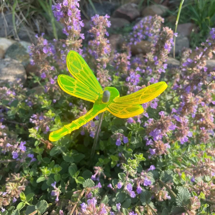 A yellow glowing dragonfly in flowers