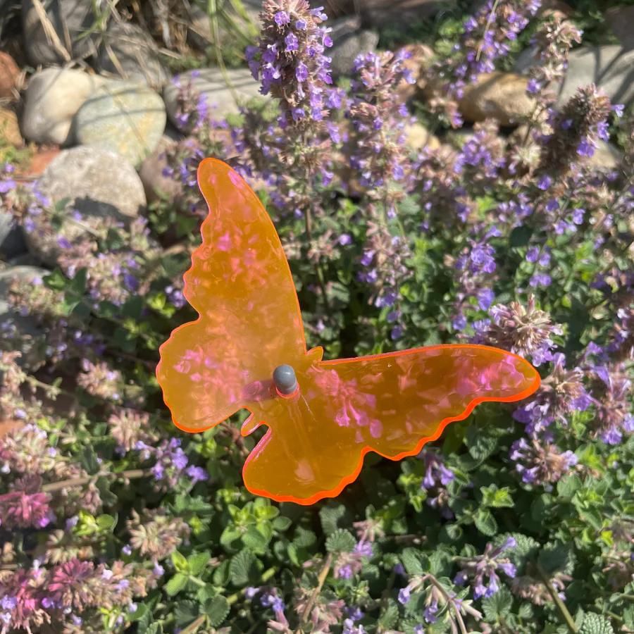 A pink glowing butterfly in flowers