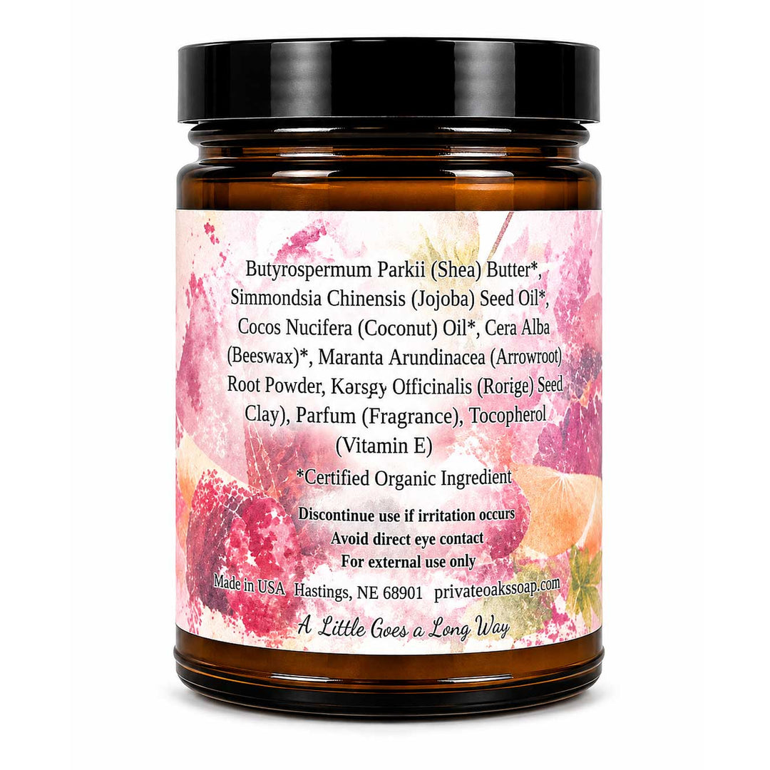 An amber glass jar of Shea Butter with a black screw cap and a colorful label, shown on a plain white background. The label contains product ingredients and branding.