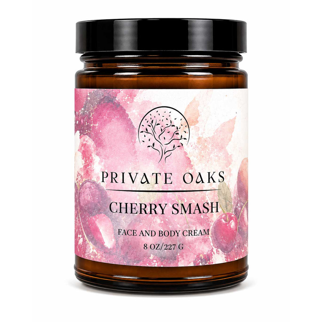 An 8 oz amber glass jar of Private Oaks Cherry Smash Face and Body Cream with a black lid and a pink watercolor cherry label, set against a plain white background.