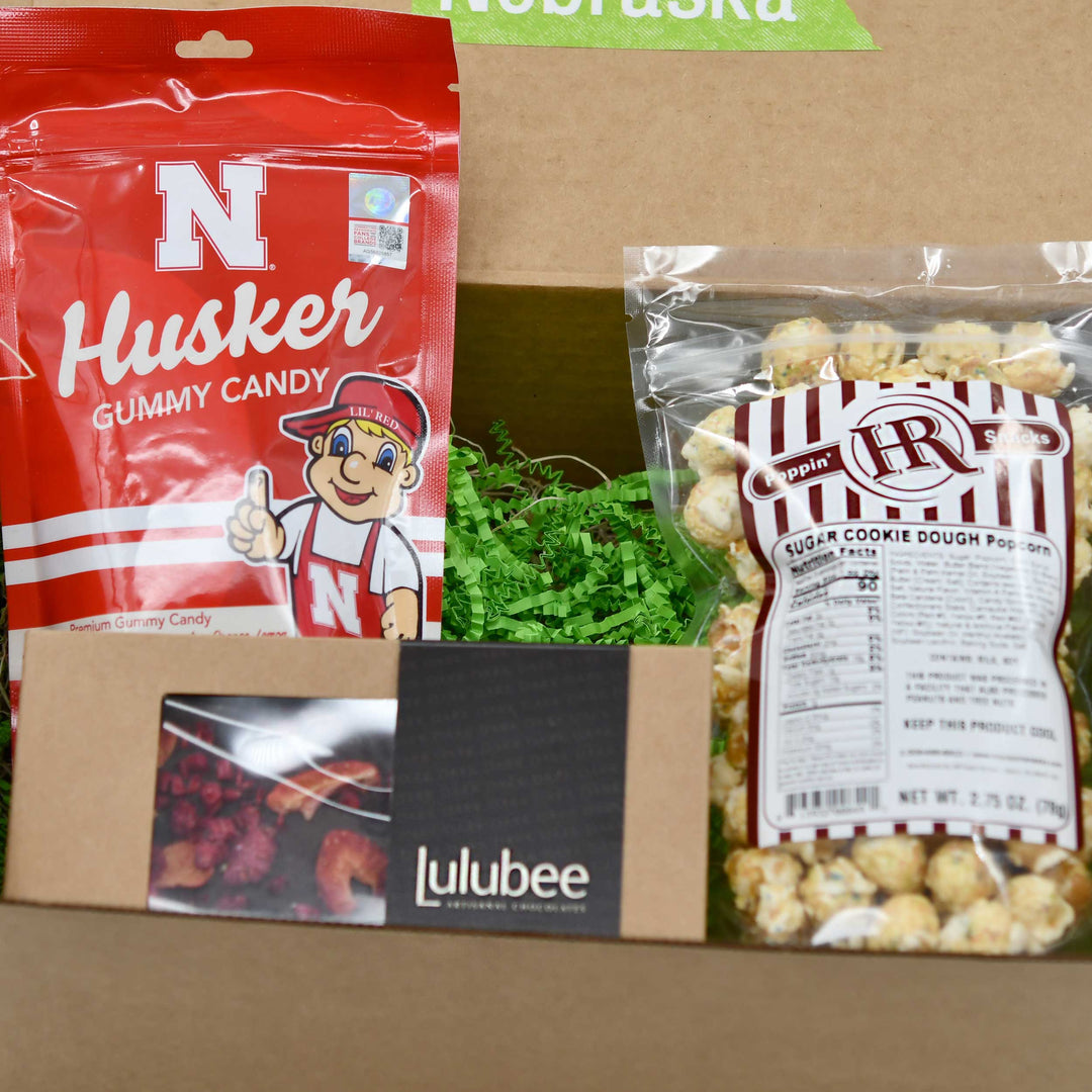 Nebraska-themed gummy candy and Popin' Hot Popcorn in a box with lulubee branding.