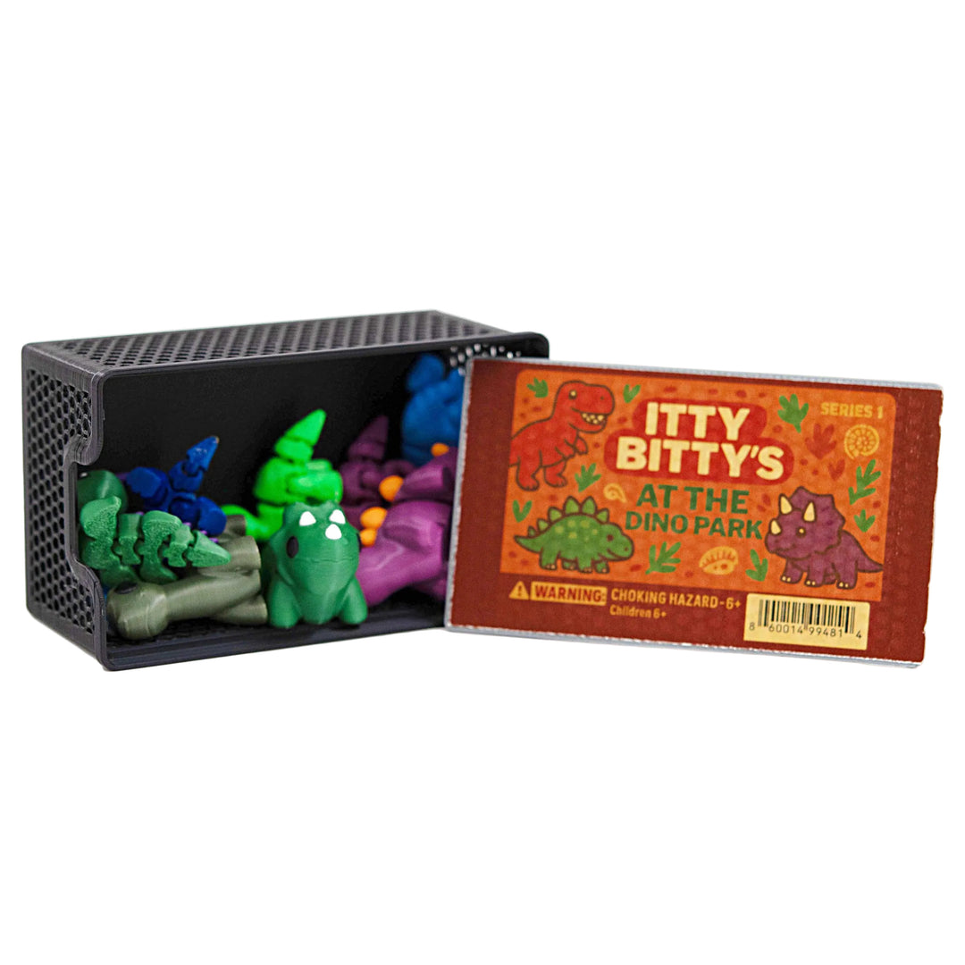 Set of colorful dinosaur toys in a black container with a matching book titled 'Itty Bitty's at the Dino Park'.