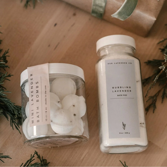 Our Lavender co mini lavender bath bombs with bubbling lavender bath fizz on a wood table with greenery surround