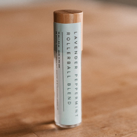 Lavender essential oil rollerball sitting on a wood table