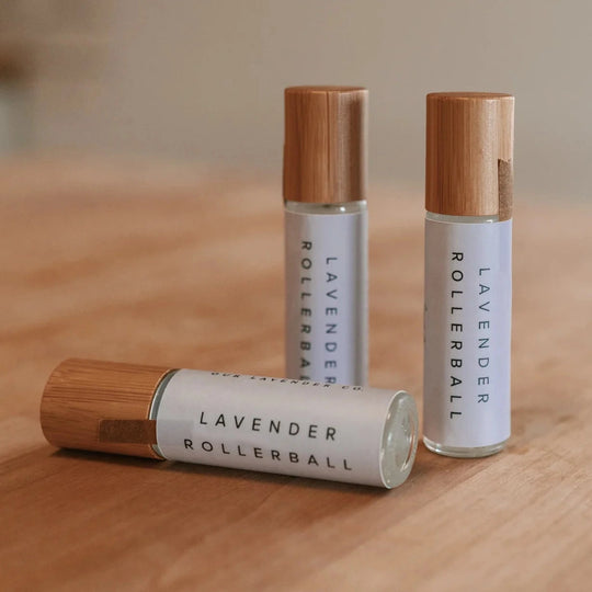 pack of three Lavender essential oil rollerballs sitting on a wood table