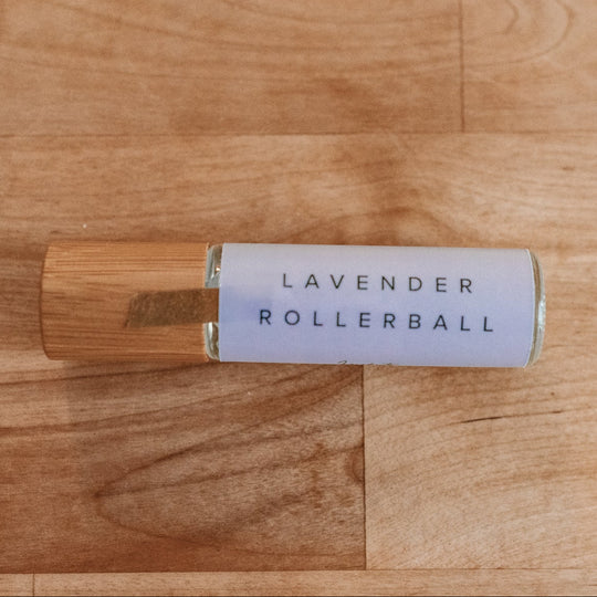 Lavender essential oil rollerball sitting on a wood table