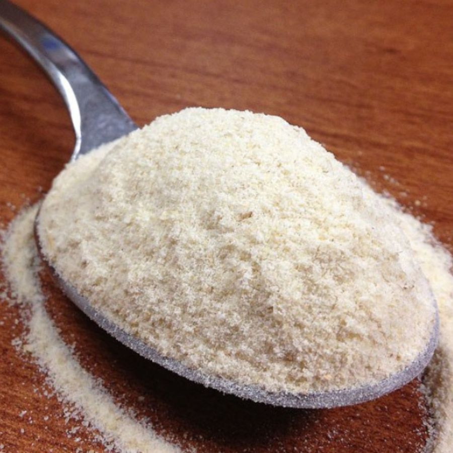 A Spoonful Of Organic Kamut Flour Laying On A Wooden Table