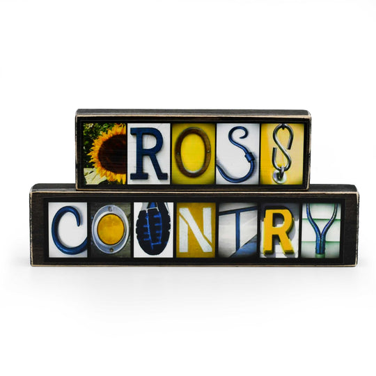 Stack of decorative letter blocks spelling 'CROSS COUNTRY' on a white background