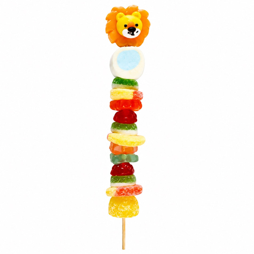 Lion candy kabob featuring a lion candy topper and assorted fruit-flavored candies on a wooden skewer, isolated on a white background.