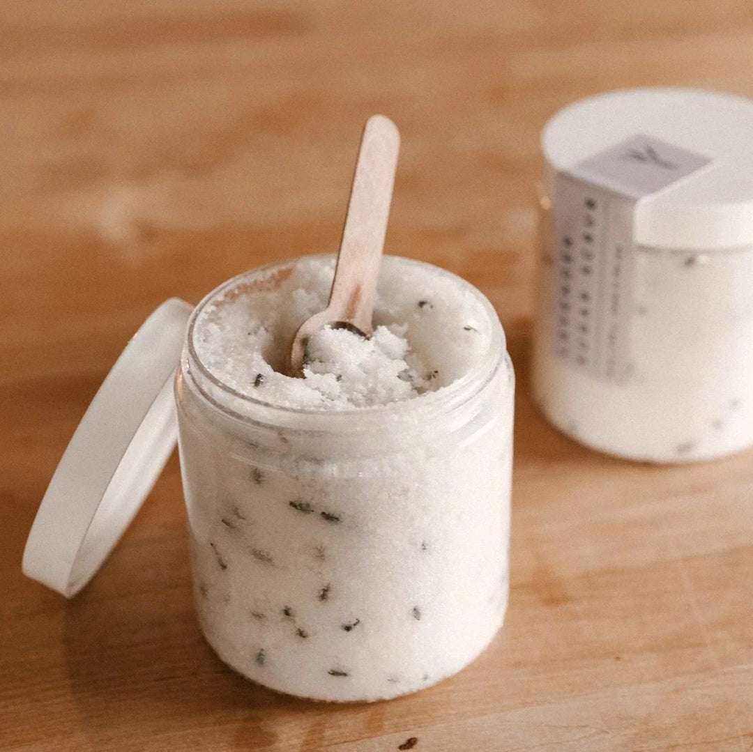 open lavender sugar scrub by our lavender co on wood table with wood spoon in open jar