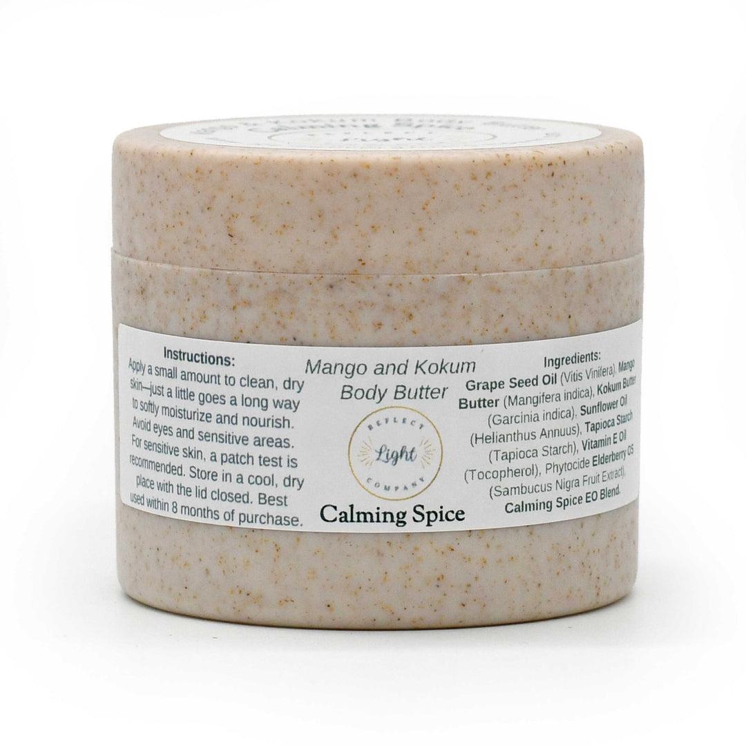 A jar of Mango and Kokum Body Butter in Calming Spice scent, featuring a speckled beige product inside a clear jar with a white label, set against a plain white background.