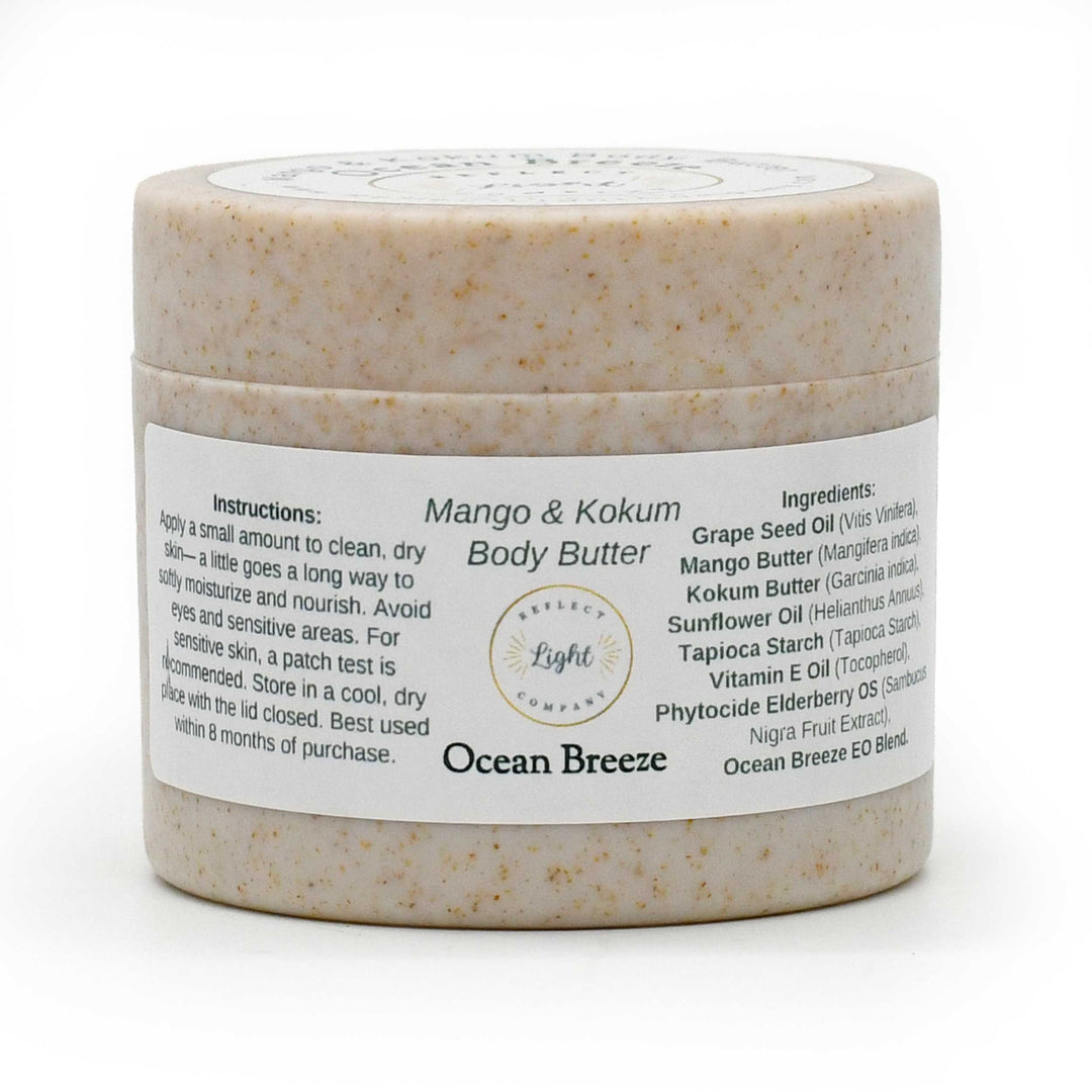 A jar of Ocean Breeze Mango & Kokum Body Butter by Belled Light Company, featuring a speckled beige product inside a clear jar with a white label.