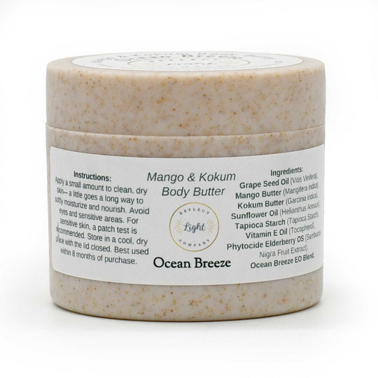 A jar of Ocean Breeze Mango & Kokum Body Butter by Belled Light Company, featuring a speckled beige product inside a clear jar with a white label.