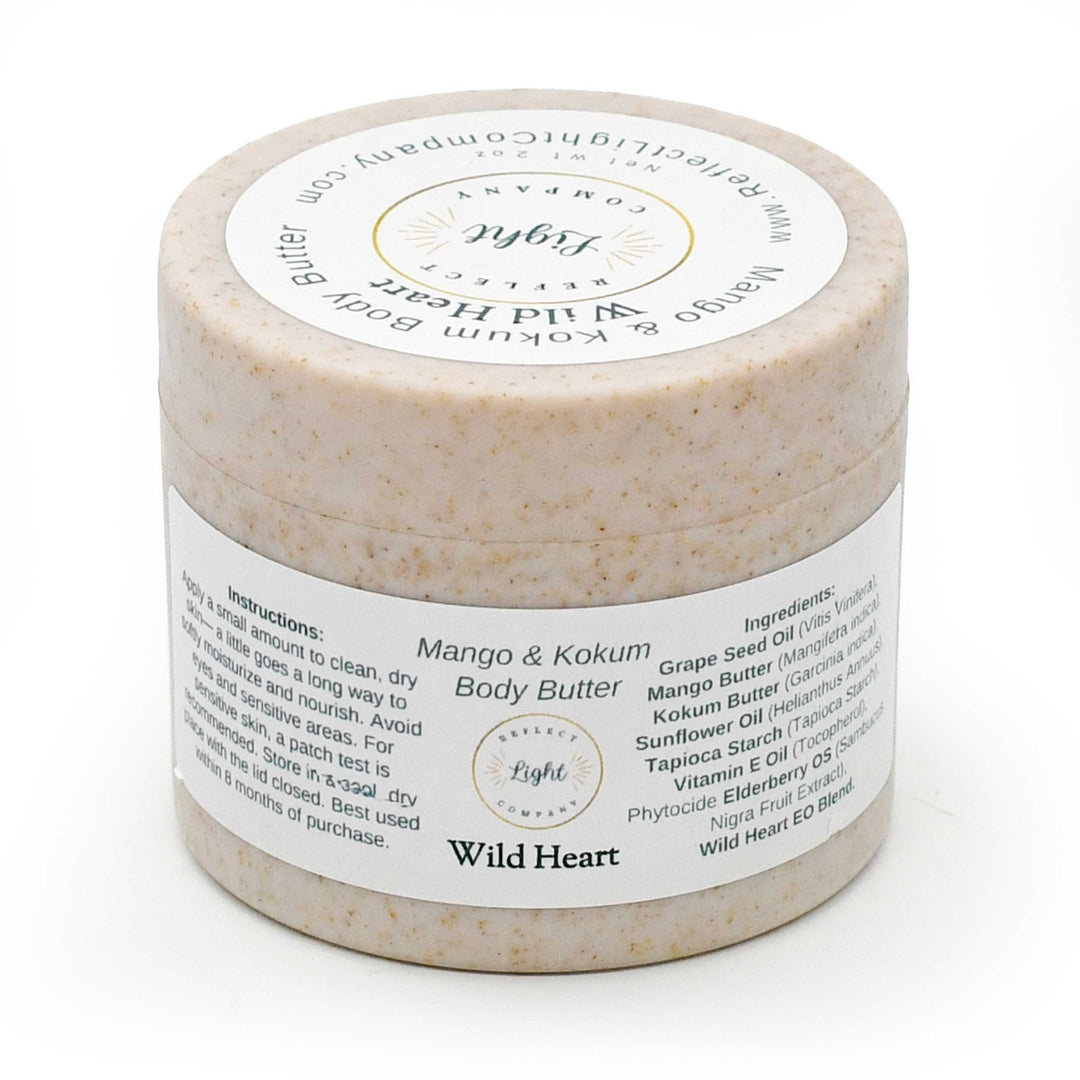 A jar of Light Reflects Beauty 'Wild Heart' Mango & Kokum Body Butter, featuring a textured beige scrub inside a clear jar with a white label, set against a plain white background.