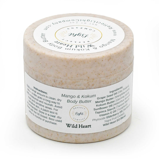 A jar of Light Reflects Beauty 'Wild Heart' Mango & Kokum Body Butter, featuring a textured beige scrub inside a clear jar with a white label, set against a plain white background.