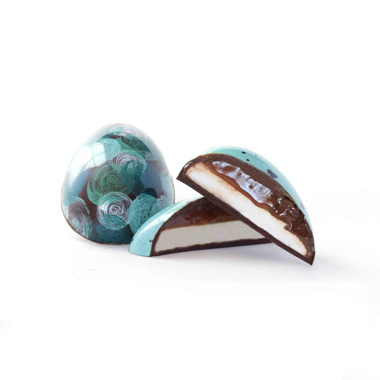 Two chocolate egg-shaped candies with marbled designs on a white background