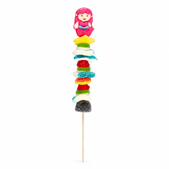 Mermaid-themed candy kabob featuring a pink mermaid gummy and assorted colorful gummy candies on a wooden skewer, isolated on a white background.