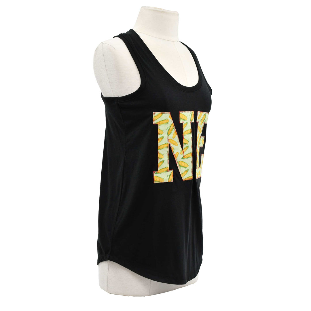 A black sleeveless tank top displayed on a white mannequin torso against a plain white background. The front features a large decorative letter 'N' filled with a yellow, green, and white tropical leaf pattern.