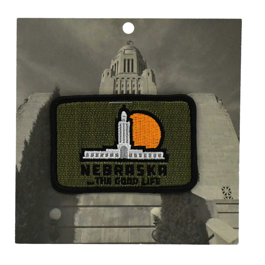 Embroidered patch with a building design and 'Nebraska The Good Life' text on a gray background