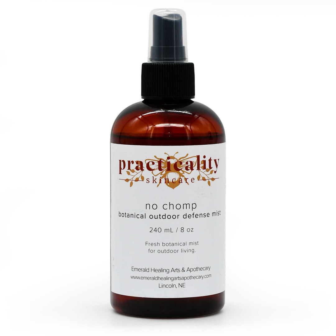 A 240 mL amber glass spray bottle of Practicity Skincare 'No Chomp' botanical outdoor defense mist, featuring a white label and black spray nozzle on a white background.