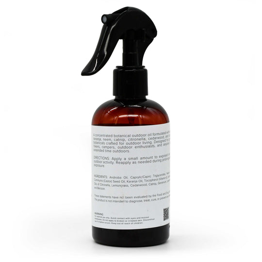 An amber glass spray bottle with a black trigger sprayer and a white label, photographed on a clean white background.