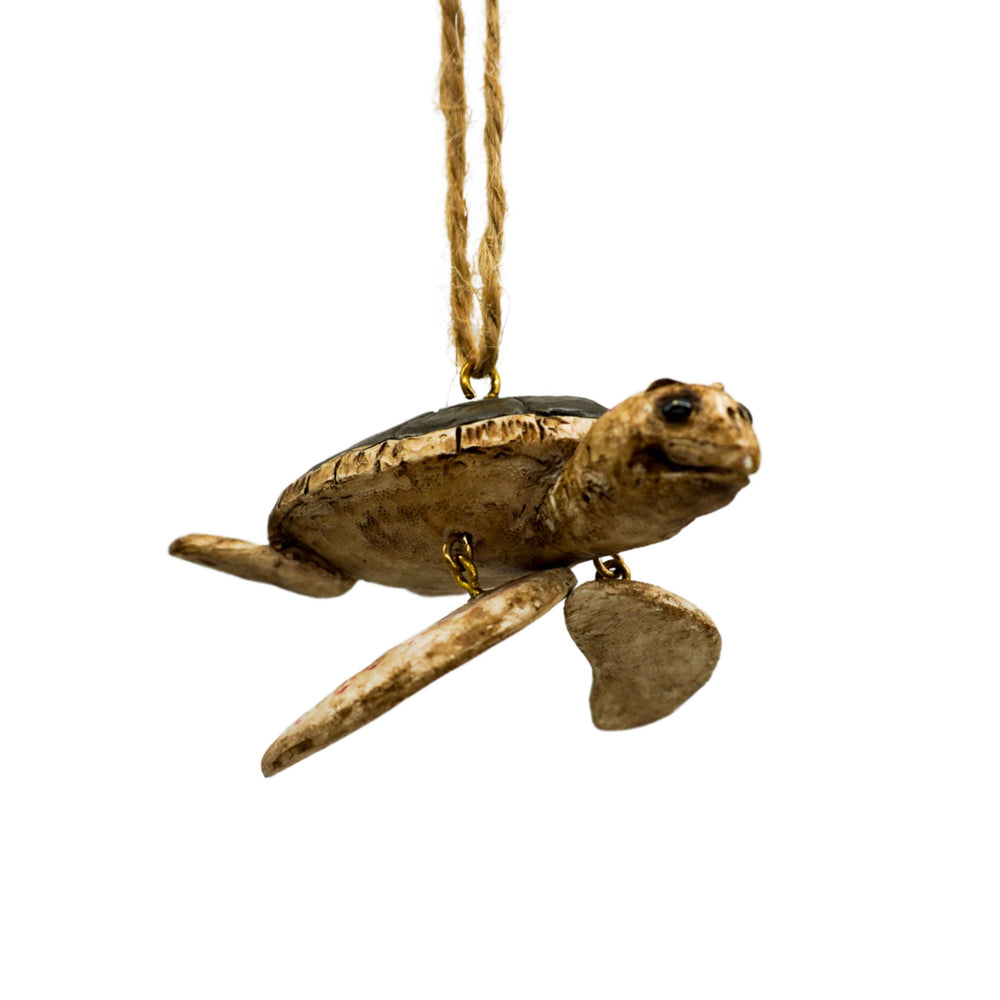 Decorative turtle ornament hanging on a string against a white background