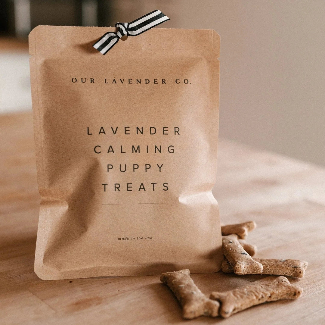 Our Lavender Co Lavender Calming Puppy Treats on a wood counter with treats outside  on table