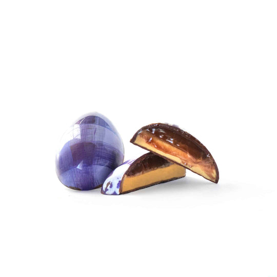 peanut butter and caramel chocolate easter egg on a white background