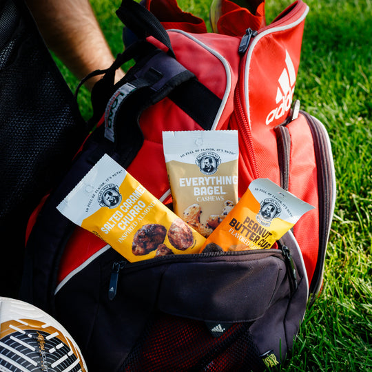 Red Adidas bag with protein bars on a grassy background