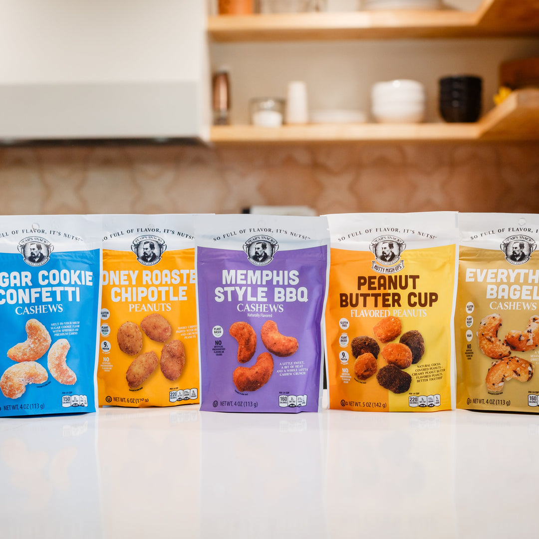 Five packages of different flavored cookies on a kitchen counter.