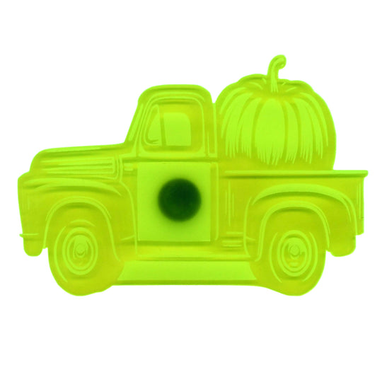 A bright neon yellow-green plastic ornament shaped like a vintage pickup truck carrying a pumpkin, shown against a plain white background.